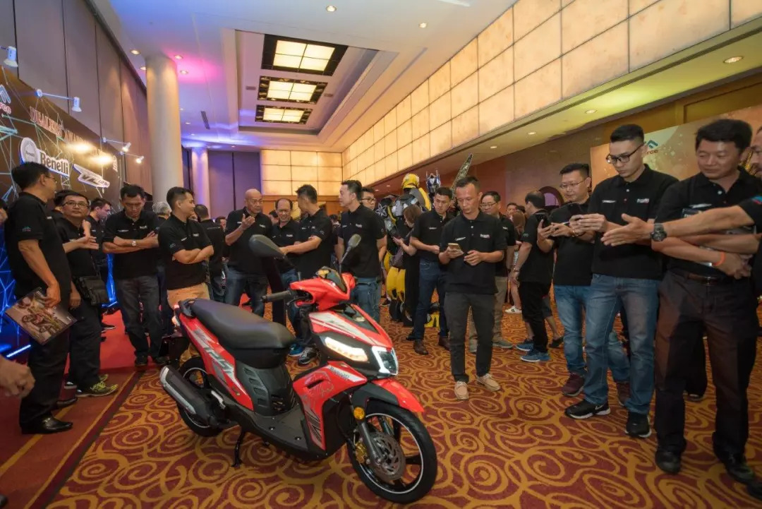 عکسی از تعداد زیادی افراد در مالزی که دور تا دور موتورسیکلت بنلی اسکوتر v125i